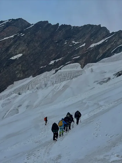 A team making their way up a vast snowfield on Friendship Peak. The scale of the mountain is truly humbling.