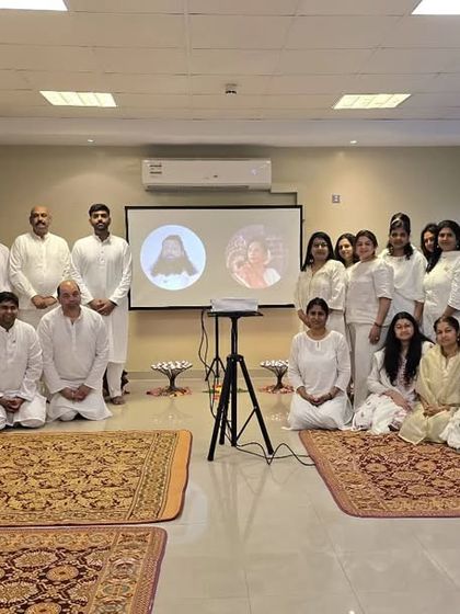 A group of participants dressed in white, gathered for our Chakra Meditation Program. This photo shows the unity and shared purpose of the community during an in-person healing event.