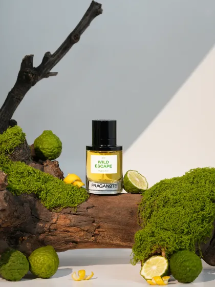 A fresh, nature-inspired shot for 'Wild Escape' perfume, using moss, wood, and bergamot fruit. We build miniature natural landscapes in our studio to match a fragrance's ingredients.