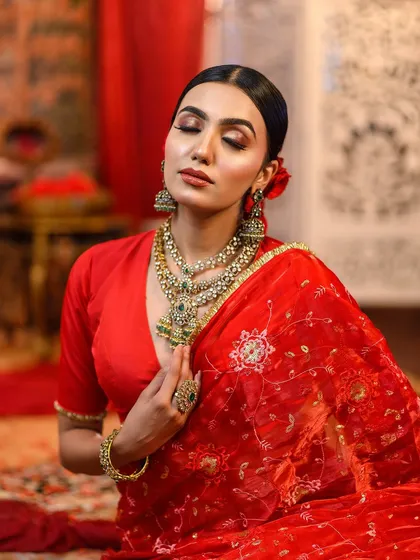 A close-up showing the soft, blended eyeshadow and flawless base of the red saree look.