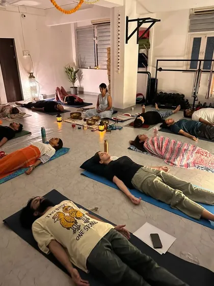 Students in deep relaxation during Savasana, completely immersed in the healing vibrations of the sound bath.