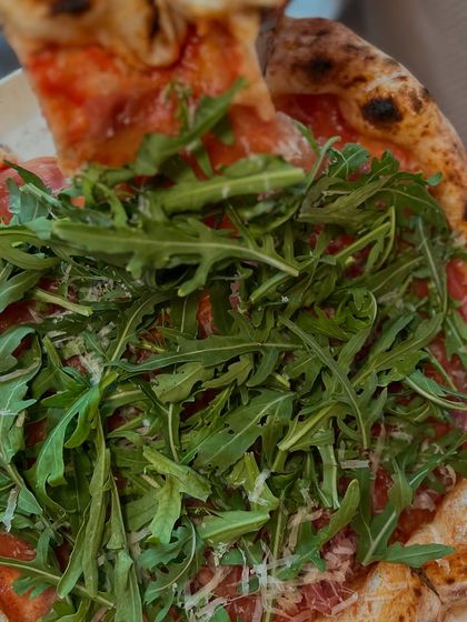 Taking the first slice of the Prosciutto di Parma e Rucola. The best moment.