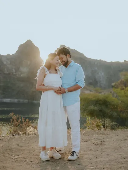 A tender embrace as the sun sets behind the mountains. This romantic, sun-flared shot captures the warmth and love between the couple.