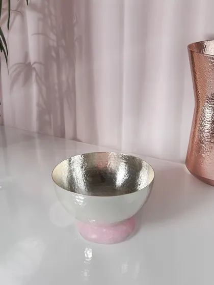 Sculptural yet functional, this hammered silver bowl rests on a solid rose quartz base. It adds just the right amount of color and charm to your table or console, perfect for holding keys or shining on its own.