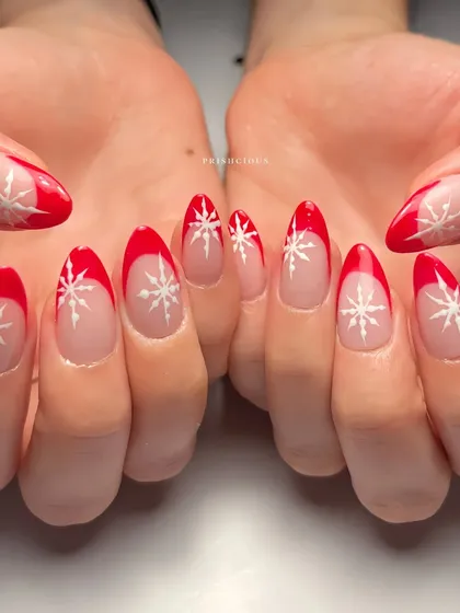 A classic Christmas look with a modern twist. This set features a crisp red French tip on an almond nail, accented with delicate white snowflake designs.