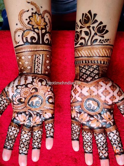 This minimalist bridal design features elephants and lotuses. The use of negative space and matching patterns on both hands creates a modern yet traditional look.