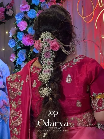 A closer look at the intricate floral braid, created with fresh roses and baby's breath. It's a dreamy and romantic hairstyle.