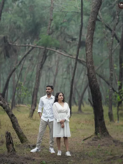 A posed shot of a couple in a misty forest. The moody atmosphere and unique trees create a mysterious and beautiful backdrop for a pre-wedding shoot.