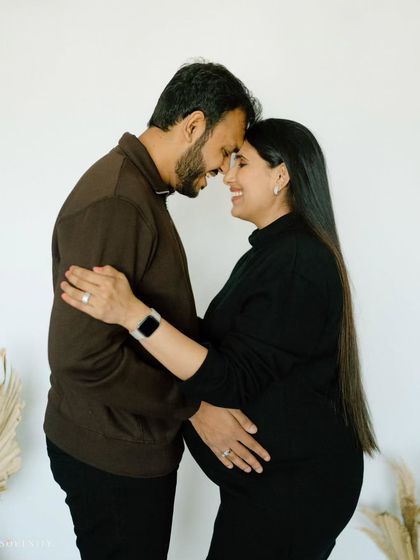 Forehead kisses and the promise of a new beginning. This intimate studio portrait captures the deep bond and anticipation of parenthood.