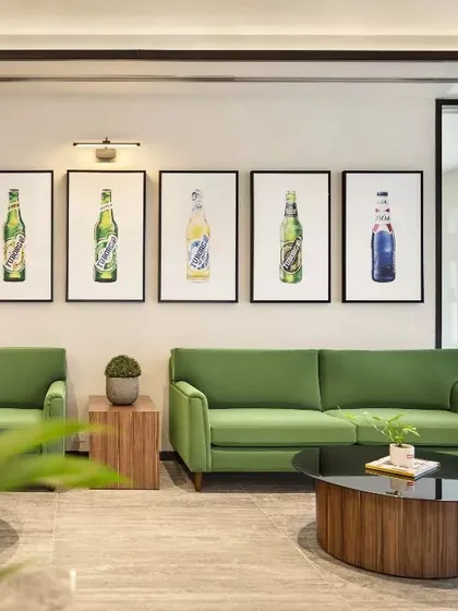 The waiting area of the Carlsberg head office, designed to immerse visitors in the brand's world. The green sofas and bottle art create a cohesive and memorable brand experience.