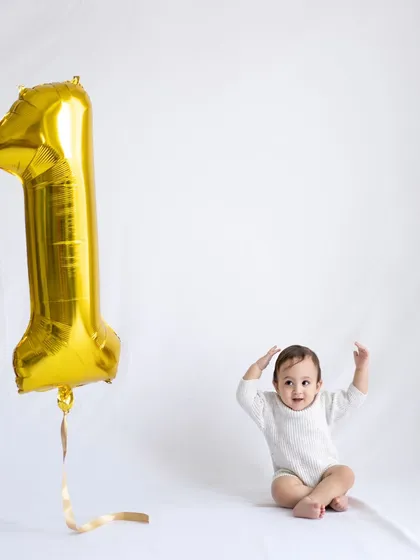 A simple and sweet first birthday portrait with a single gold "1" balloon. Sometimes less is more.