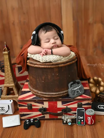 Adventure awaits this little dreamer. Our travel-themed setup, featuring vintage suitcases and a tiny passport, is perfect for capturing the journey ahead. This classic 'chin-on-hands' pose shows just how peaceful and sweet the newborn stage is.