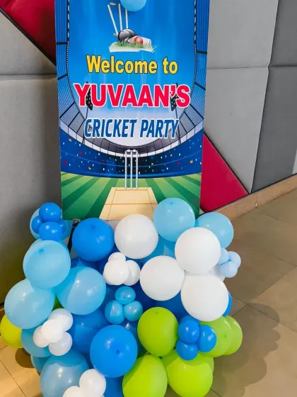 A custom welcome standee for Yuvaan's cricket party, designed to look like a stadium entrance, complete with a balloon cluster in the team's colours.