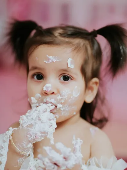 A close-up that captures the delicious mess. You can almost feel the texture of the frosting and the joy of the moment.