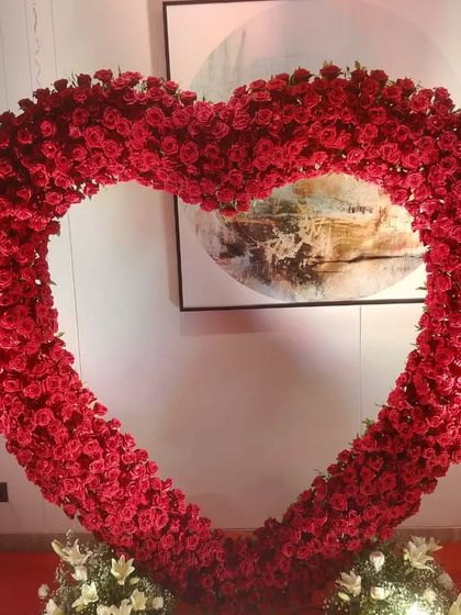 A close-up of the stunning heart-shaped arch made entirely of artificial red roses, which served as the centerpiece for a romantic birthday party.
