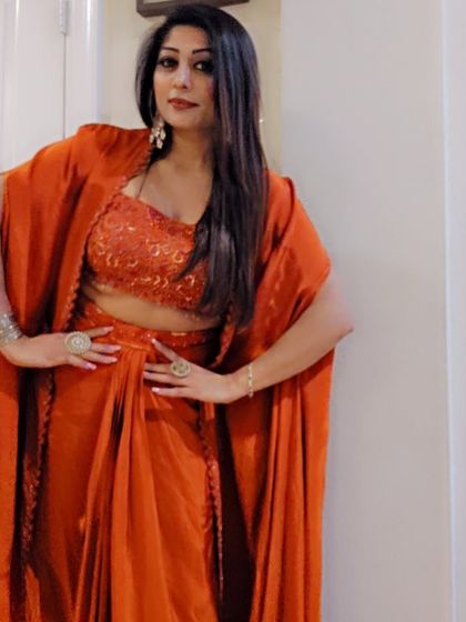 A client rocking a three-piece fusion set with a lace crop top and a flowy cape. Her confidence makes the outfit shine even brighter.