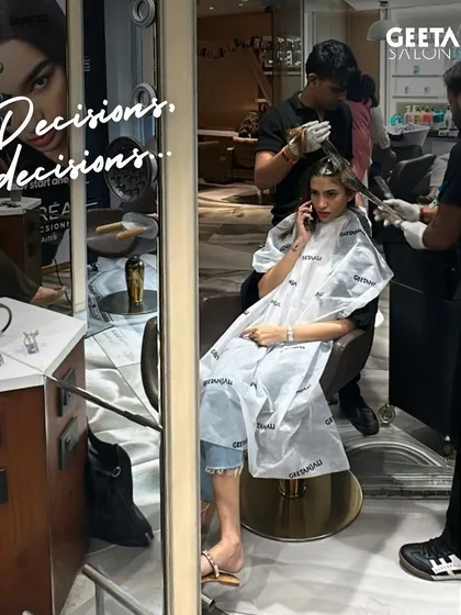 Decisions, decisions. A client on the phone while her colour is being applied, a common sight during the transformation process.