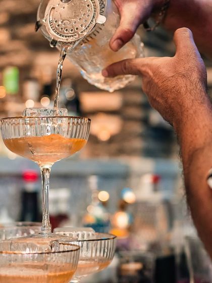 The art of the pour. A bartender creates a beautiful cocktail tower, a signature element of our celebratory brunches and events at Terra.