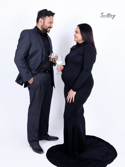A sophisticated full-length portrait of a couple dressed in black. Their elegant pose and the clean white background create a modern and timeless look.