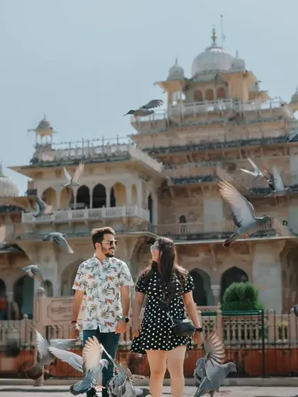 A candid moment of the couple walking hand-in-hand through the pigeons at Albert Hall. This captures the feeling of a relaxed, romantic day out in the city.