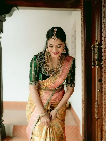 A playful, happy moment captured. The bride's smile and the vibrant saree create a picture of pure joy.