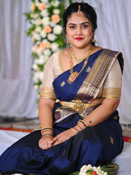 This client looks regal in a deep blue Kanchivaram saree paired with a contrasting beige blouse with simple gold border detailing.