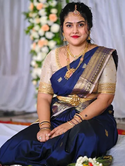 This client looks regal in a deep blue Kanchivaram saree paired with a contrasting beige blouse with simple gold border detailing.
