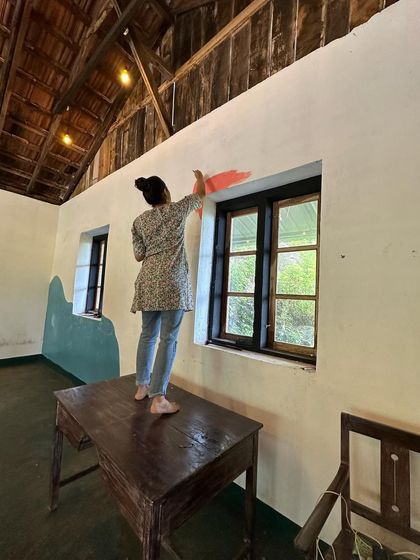 Painting above the window frame for the hostel mural in Kerala. I love working in unique spaces with interesting architectural features like this wooden-beamed ceiling.