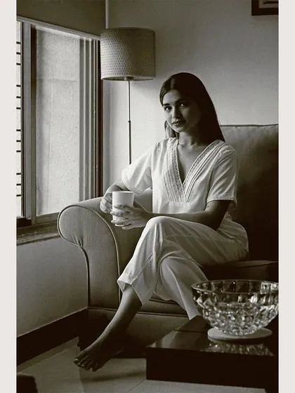 A moody, black and white portrait to add an artistic touch to the lookbook. This shot emphasizes the form and texture of the white loungewear set, creating a timeless and sophisticated feel.