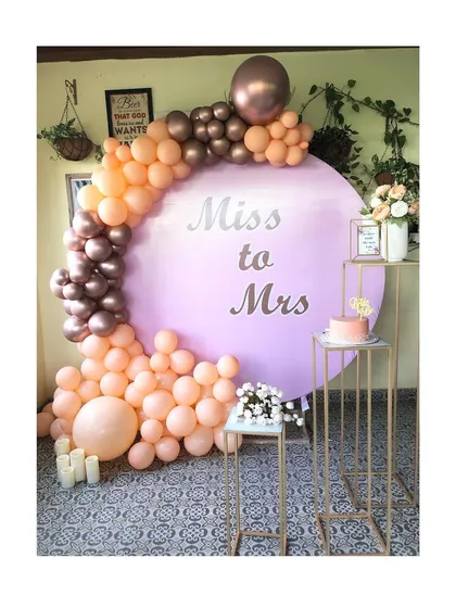 For the bride and her tribe, I create chic, photo-ready spaces. This popular 'Miss to Mrs' circular backdrop, paired with a custom peach and rose gold organic balloon arch, is perfect for a modern bridal shower.