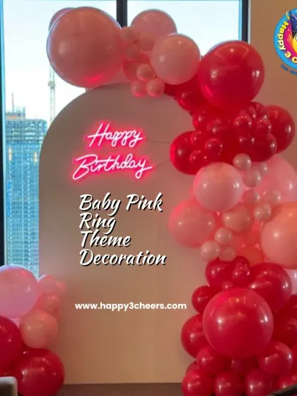 This baby pink ring theme is a simple yet elegant choice for a birthday. The balloon arch in shades of pink and red against a clean white backdrop with a neon sign is modern and chic.