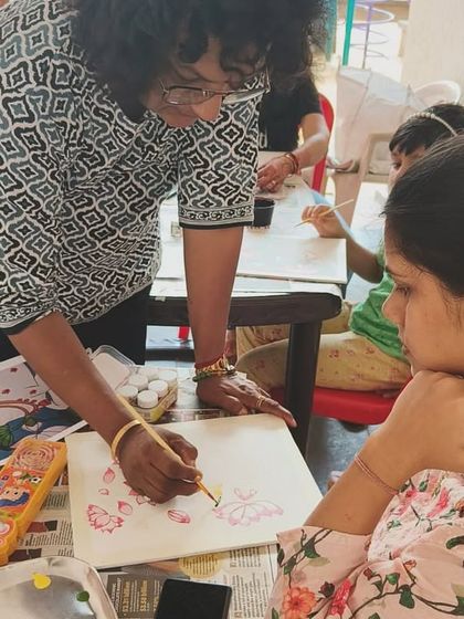 I believe in hands-on guidance. Here, I'm demonstrating a brush technique to a student during our Pichwai workshop, ensuring everyone feels confident in their work.