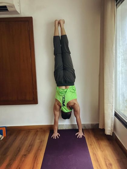 My student Charles holding a strong handstand against the wall. Handstands are incredible for building shoulder stability, core strength, and reversing blood flow.