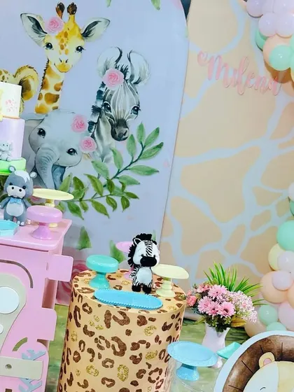 This view highlights the pastel balloon garland that frames the safari backdrop, adding softness and color to the overall wild theme.