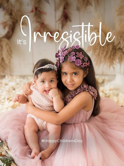 An adorable portrait of two sisters for Children's Day. The older sister gives her baby sister a loving hug in this irresistibly sweet photo.
