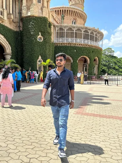 Walking through the paved courtyard of Bangalore Palace, with its vine-covered walls in the background.