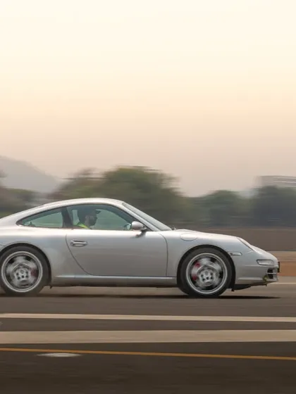 This panning shot of a silver Porsche 911 captures its classic lines while conveying a strong sense of speed and movement.