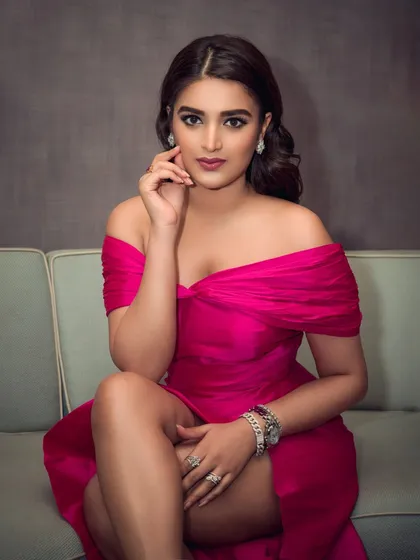 A full-length portrait of actress Nidhhi Agerwal in a stunning magenta gown. This shot was taken for an event, capturing her elegance and the dress's beautiful silhouette.