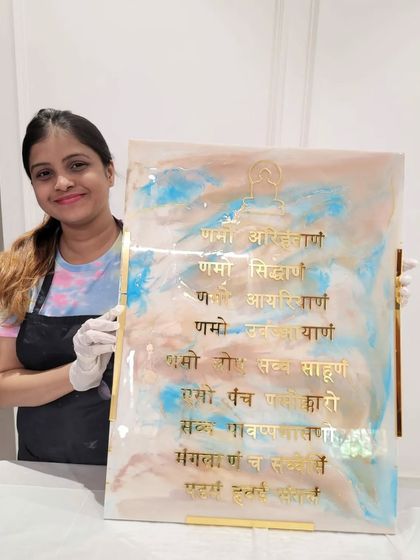 A proud student holding the Navkar Mantra frame she created during our resin art workshop. It's wonderful to guide someone as they make their very own piece of spiritual art.