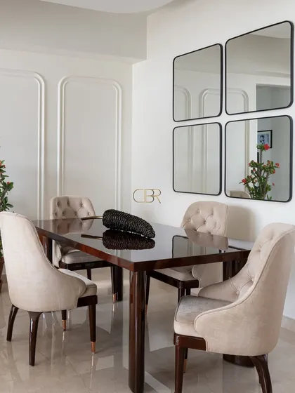 The dining area is where families come together, and I designed this space to feel both elegant and welcoming. The clean lines of the dark wood table are softened by upholstered chairs and the strategic use of mirrors, which expand the space and reflect light, creating an intimate setting for shared meals.