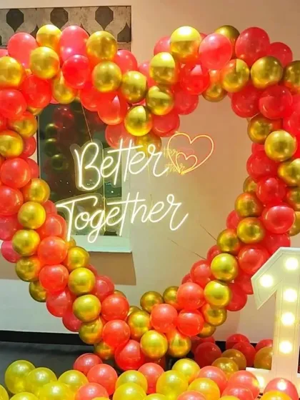 For a truly romantic statement, I can create a large, heart-shaped balloon arch. This "Better Together" setup, made with red and gold balloons and a central neon sign, is perfect for a first anniversary, Valentine's Day, or any romantic celebration.