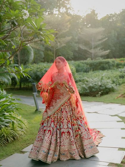 A bride in her element. The movement of the veil and the lush garden setting create a portrait that is both dynamic and serene, capturing the bride's natural grace.