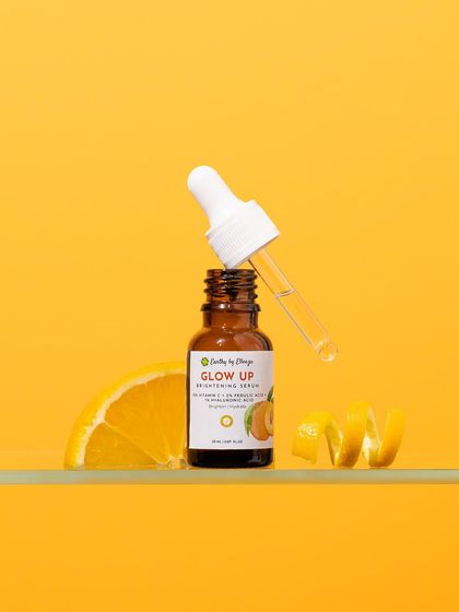 A burst of sunshine for a brightening serum. We used a vibrant, monochromatic yellow setup with fresh orange slices and peels to create an energetic and joyful image that instantly communicates the product's Vitamin C benefits.