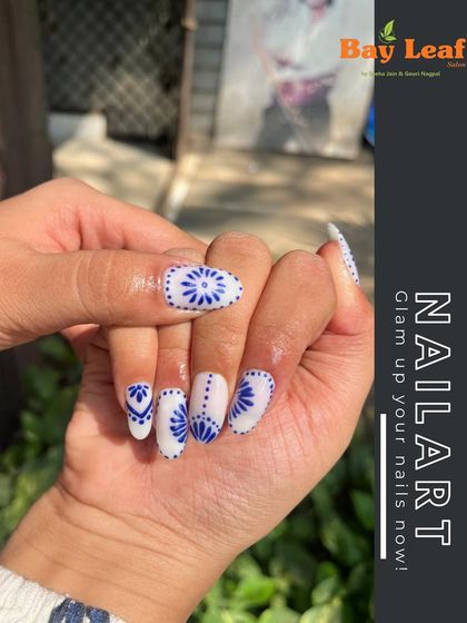 Glam up your nails with this intricate blue and white design. Inspired by beautiful porcelain patterns, this freehand art is perfect for a unique and elegant look.
