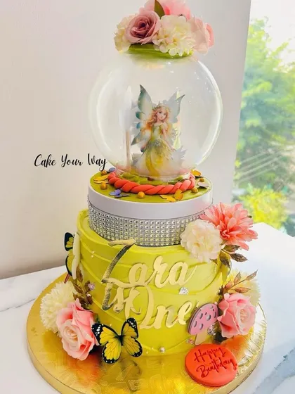 A sweet blend of florals, butterflies, and fairy magic in this rotating globe cake.