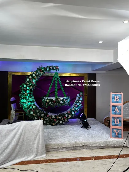 I love creating unique designs like this one for a naming ceremony. The centerpiece is a large crescent moon made of flowers, with a beautifully decorated floral cradle hanging in the center, creating a magical photo opportunity.