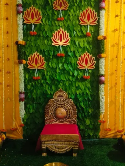 A full and centered view of the half saree function stage, showing the beautiful symmetry of the betel leaf wall and the surrounding floral decorations.