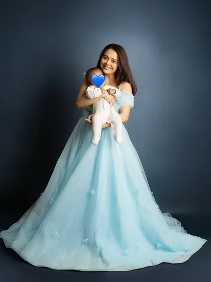 A full length portrait showcasing the stunning gown and the sweet moment between mother and child. It's an honor to capture these memories for public figures.