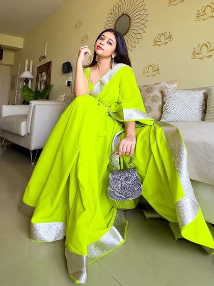 A full view of the neon saree, showing the beautiful drape and the elegant silver border. It's a simple design that makes a huge impact because of the color.