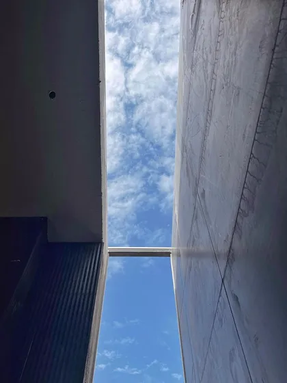 A shot looking up at the sky through a gap in the structure during construction. We always look for opportunities like this to create moments of connection with the outside, framing the sky and bringing in light.